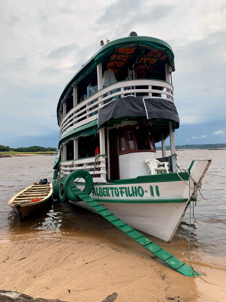 Barco de rede atracado em praia de rio